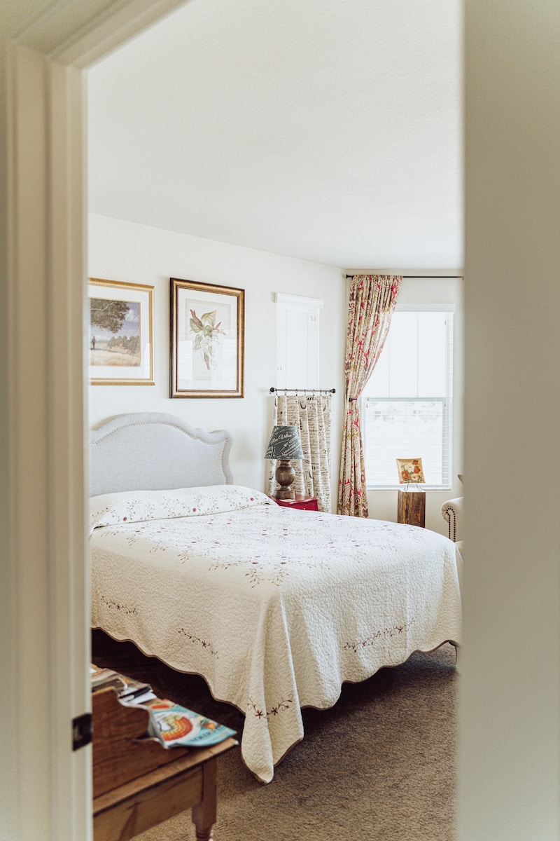 white bed linen near brown wooden framed mirror